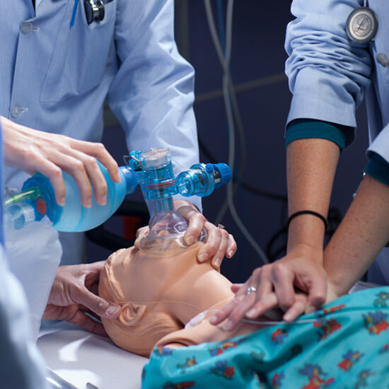 Physicians practice reviving a simulation dummy.