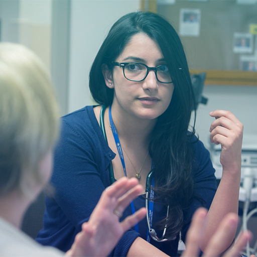 A resident speaks with a patient