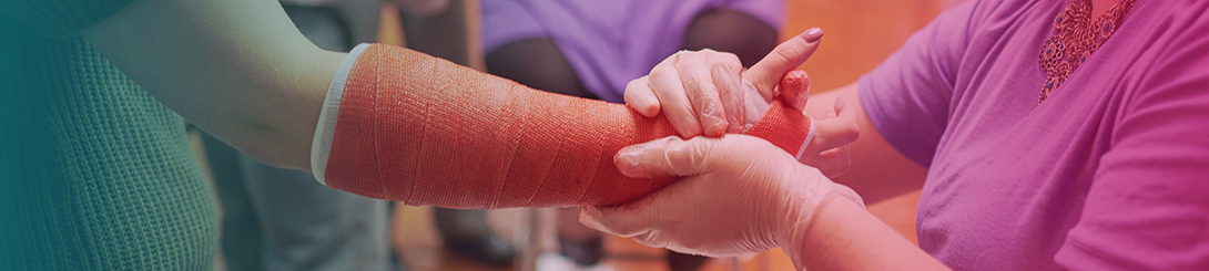 A resident examines a patient wearing a cast on their arm