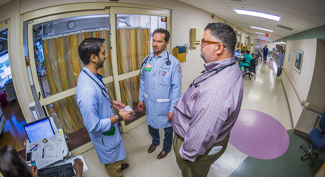 An Internal Medicine resident talks with two faculty members.
