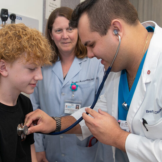 a doctor uses a stethoscope on a child.