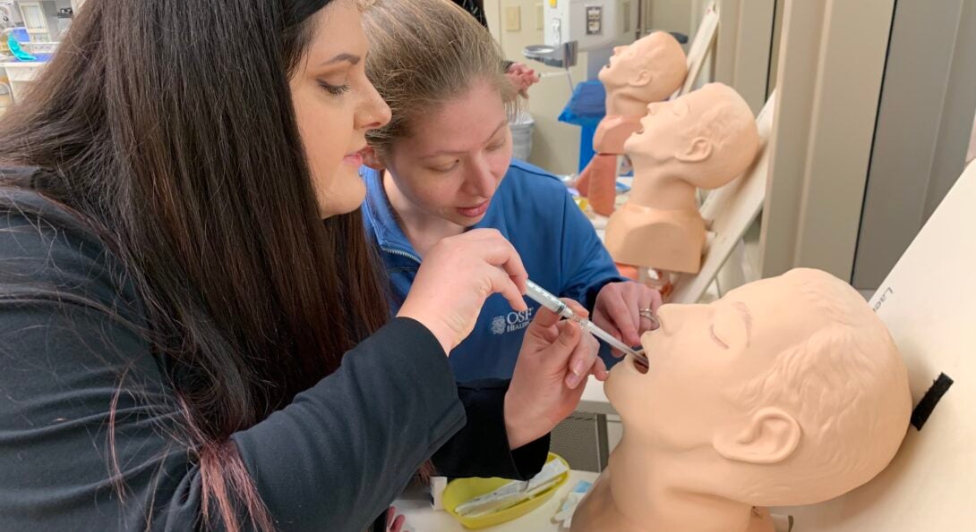 Emergency Medicine Residents practice on a manikin head