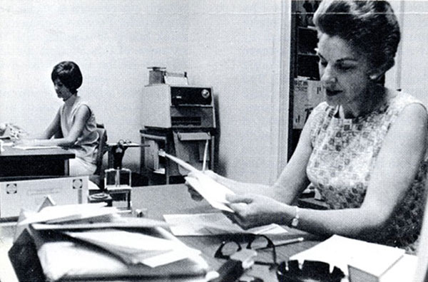 First employee of The Peoria School of Medicine Mrs. Midge Parks, sitting at her desk