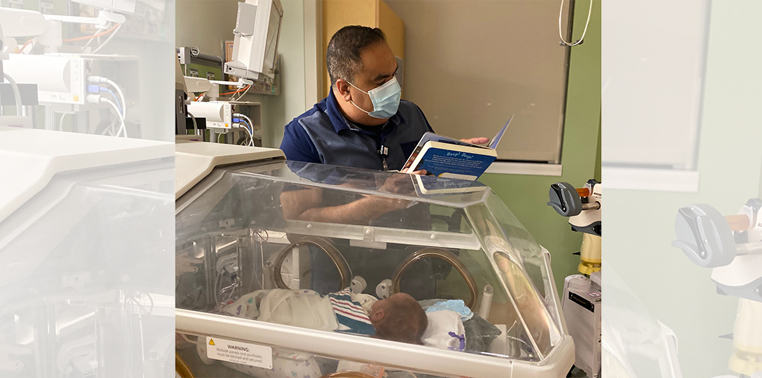 Dr. Javed reads to a baby in the NICU