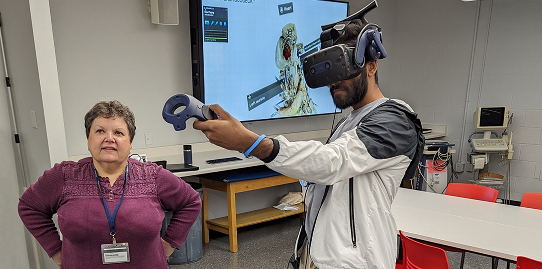 Medical student examines a 3D heart model with VR headset