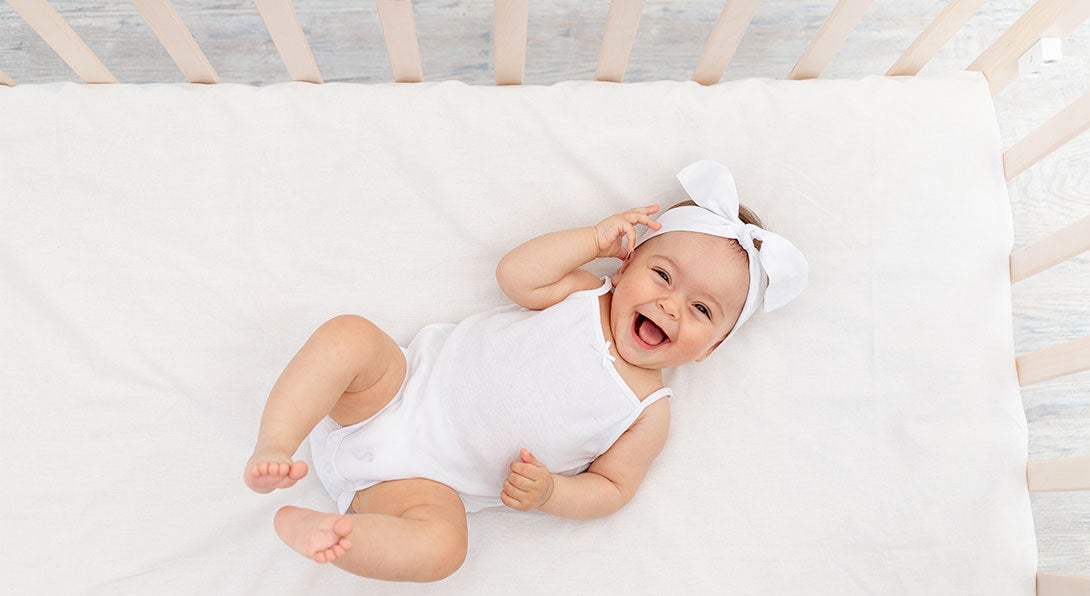 newborn baby in a crib on its back