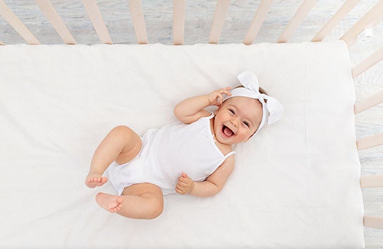 baby laying on its back in a crib