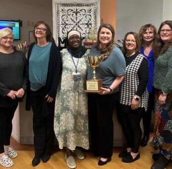 Family Medicine faculty and staff pose with the Outstanding Team Award trophy
                  