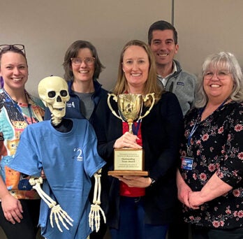 Student Affairs staff members pose with the Outstanding Team Award trophy
                  