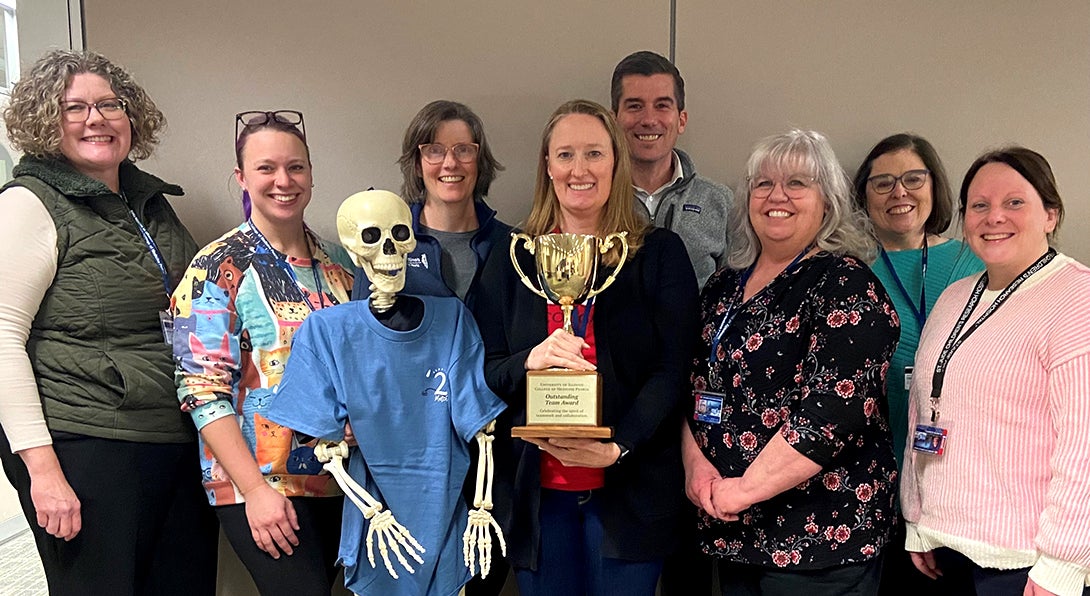 Student Affairs staff members pose with the Outstanding Team Award trophy